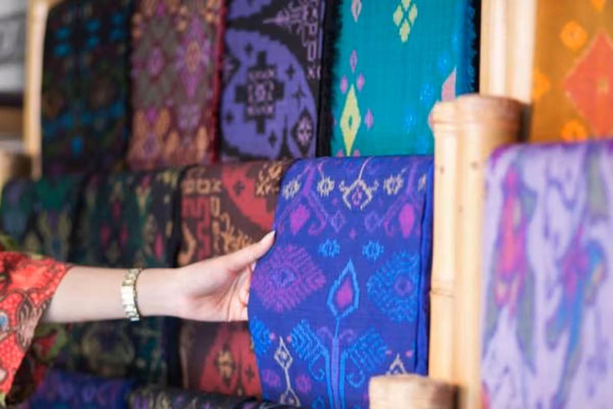 Kain Endek Bali dengan motif ikat warna-warni dan Songket berbenang emas mengkilap diperagakan penenun